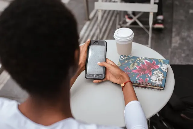 Person using a mobile device at a coffee shop table