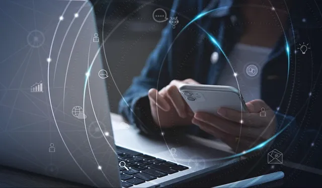 Person using a mobile device and a laptop, push notification icons