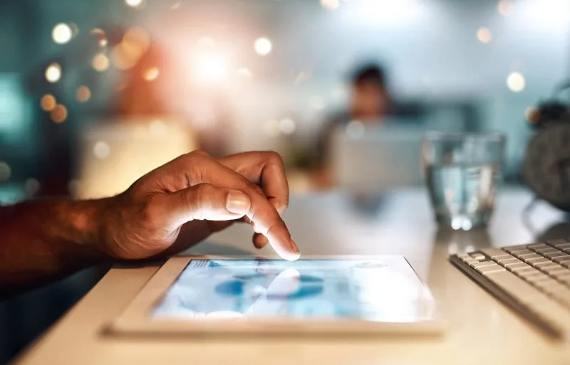 Person's hand touching a tablet screen