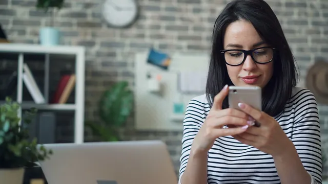 Smiling person receiving a web push notification on a smartphone